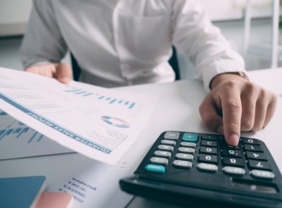 Business accounting concept, Business man using calculator with computer laptop, budget and loan paper in office.