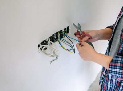 Unrecognizable female electrician working on the electrical installation of a house