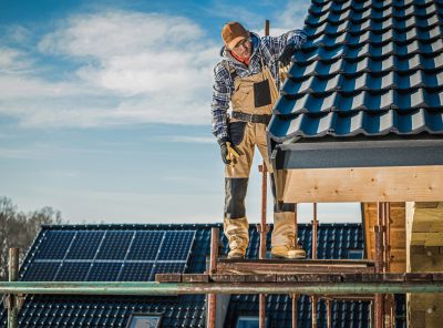 Ceramic Tiles House Roof Construction. Contractor Worker on Scaffolding Taking Last Look on the Finished Rooftop. Roofing Industry.