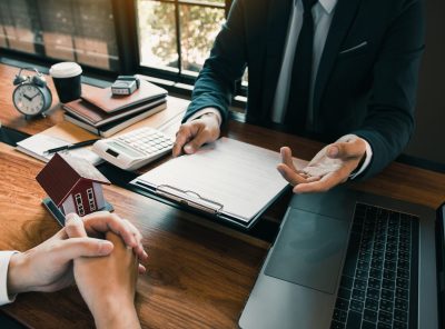 Insurance brokers are pointing to insurance contract signing and are explaining to customers at the office.