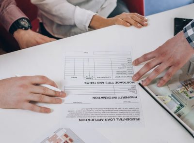 Young couple reading and preparing to sign mortgage contract in real estate agency office.
