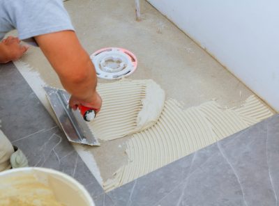 The master the tile industrial tiler builder worker installing floor tile